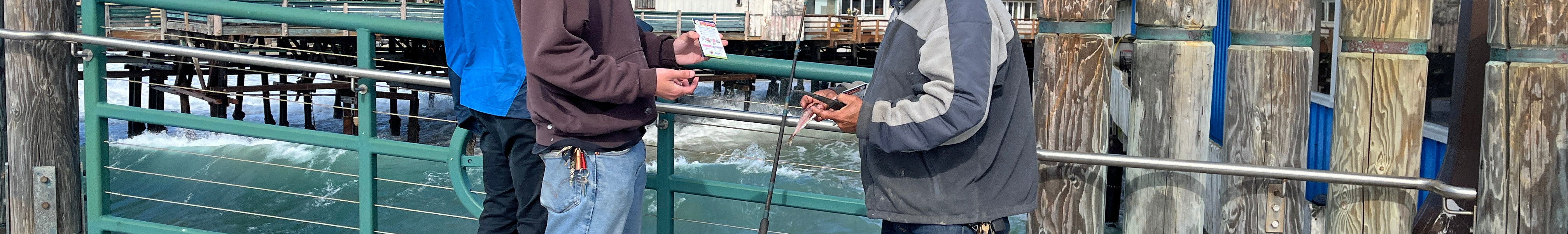 Volunteer handing out pamphlets on a pier